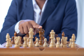 Businessman  hand moving of playing chess   strategy
concept: symbol confident new strategy plan for win and success, sports game  thinking battle planning object achievement queen for successful
