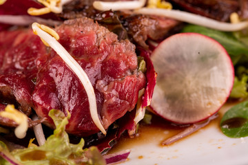 Warm beef salad with terriaki sauce, served with radish, lime and fresh salad