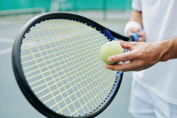 Close-up image of tenning player getting ready to hit the ball and start playing