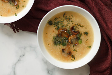 home cooking. mushroom soup puree in a white plate on a wooden table