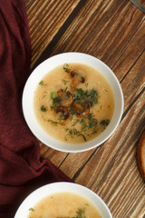 home cooking. mushroom soup puree in a white plate on a wooden table