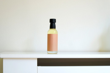 Small mini bottle of flavoured liquid coffee syrup against a white background