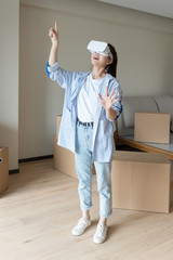 A young asian woman is using VR glasses