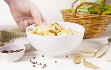 Homemade russian pelmeni meat dumplings italian ravioli in the white bowl.