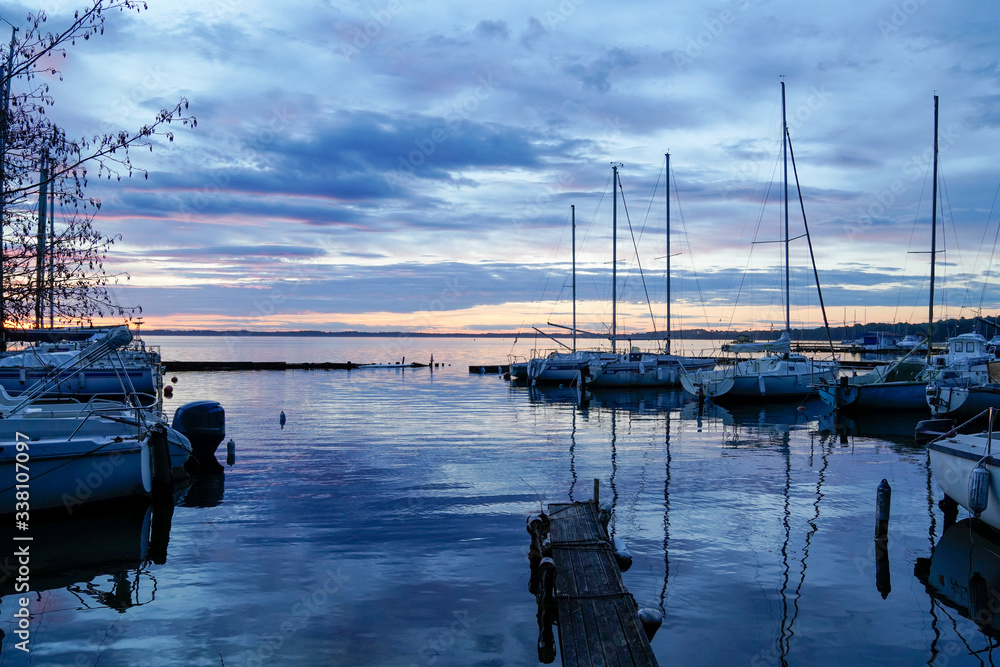 Wall mural sunrise or sunset on blue water marina boats in lake of biscarrosse landes france