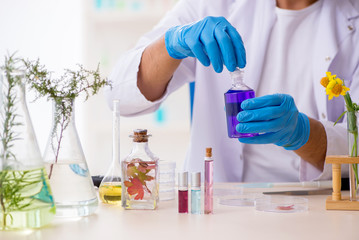 Fototapeta premium Young male chemist in perfume synthesis concept