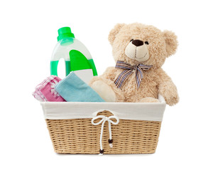 teddy bear washing clothes in a laundry basket