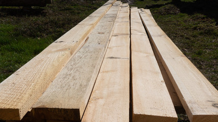 a pile of fresh pine planks on the ground