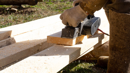 a man planing with a black electric plane