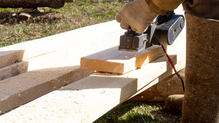 a man planing with a black electric plane