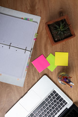 cuaderno sobre escritorio acompañado de lapiceros, marcadores con espacio en blanco para poner texto