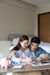 A young asian couple is sitting on the carpet planning