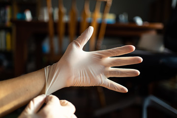 wearing disposable latex gloves to avoid the contact with viruses on the frequently touched surfaces