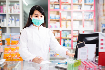 Young chinese druggist in protective facial mask