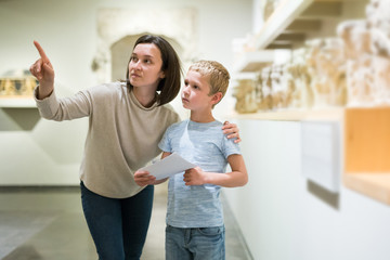 Woman and boy observing sculptures exhibition