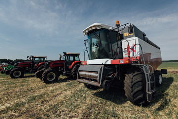 white red harvester on a sunny day in a field