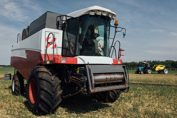 Fototapeta premium white red harvester on a sunny day in a field