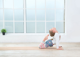 Little girl practicing yoga poses. Cute little girl do fitness exercise. Copy space.