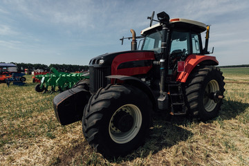 red tractor with large wheels in the field during tests during the exhibition