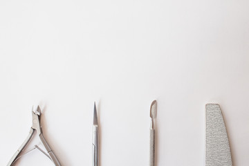  manicure set on a white background: scissors, pusher, nail file, tongs. professional pedicure tool.