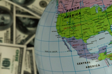 Fototapeta premium Globe lying on the background full of money