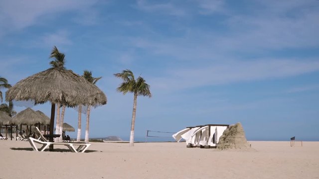 Beds with curtains moved by the wind in the beach.