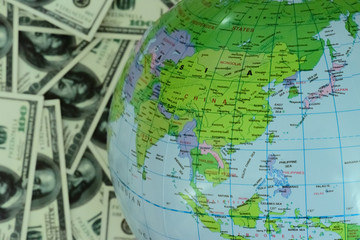 Globe lying on the background full of money