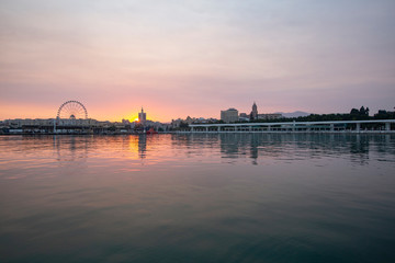 Obraz premium sunset landscape with the sea and buildings in the background
