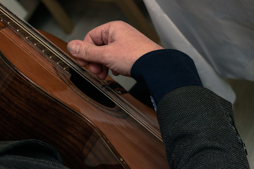 Fototapeta Męska dłoń grająca na gitarze w marynarce obraz
