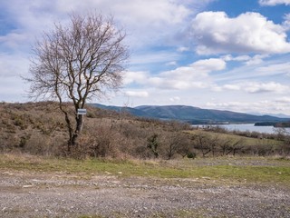 Sign on a tree indicating a parking lot on a hill at the Ullibarri-Gamboa Reservoir, Alava, Basque Country, Spain