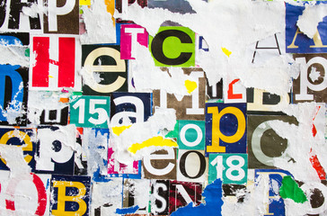 Torn and peeling pieces of dirty paper layers on colorful collage from clippings with letters and...