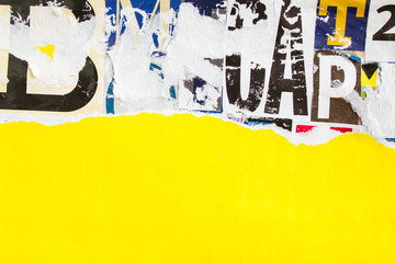 Torn and peeling piece of yellow paper placard poster on colorful collage from clippings with letters and numbers texture background. Copy space for text message.