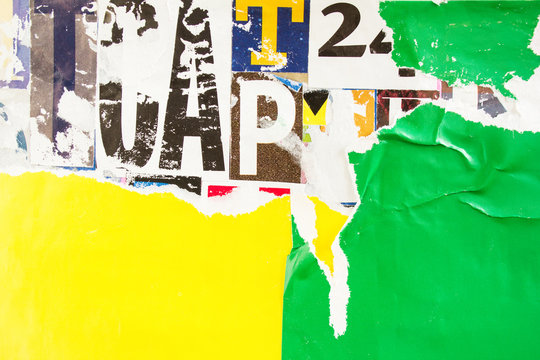 Torn and crumpled green and yellow paper poster placards on colorful collage from clippings with letters and numbers texture background. Copy space for text message.