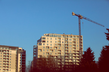 A high multi-family apartment block against a blue sky.