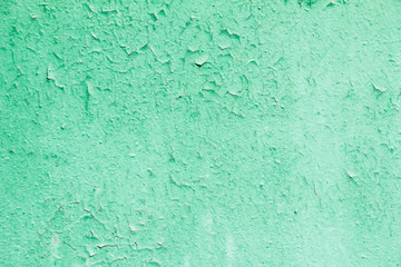 Old green painted metal surface with cracked and peeling paint texture background.