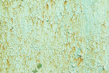 Old green painted rusty metal surface with corrosion and stains. Green dirty wall with cracked and peeling paint texture background.