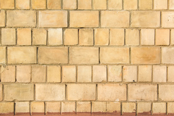 Old brown beige brick wall with big and small blocks background.