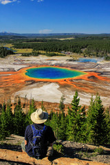 Tourist enjoying the view of Grand Prismatic Spring in Midway Geyser Basin, Yellowstone National Park, Wyoming, USA.