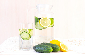 Health care, fitness, healthy eating concept. Fresh cool lemon cucumber drink with water, cocktail, detox drink, lemonade in a glass jug and a glass.