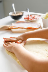 A girl´s hands preparing a pizza dough to place the ingredients