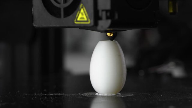 4K The 3D printer prints white plastic model of egg. modern technology.