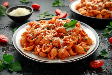 Conchiglie rigate pasta with chickpeas in tomato sauce with parmesan cheese. Healthy vegan food.