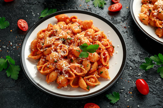 Conchiglie rigate pasta with chickpeas in tomato sauce with parmesan cheese. Healthy vegan food.