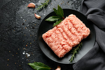 Raw Turkey breast fillets minced meat on black plate ready to cook