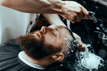 YOUNG HANDSOME BEARDED MAN IN BARBERSHOP
