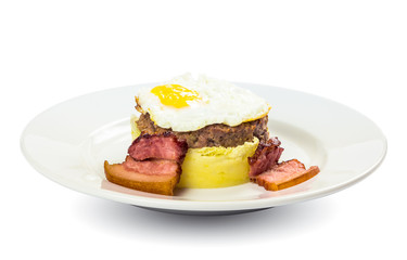 healthy homemade breakfast. fried egg and meat patty on top of smashed potato, decorated with bacon. food isolated on the white background