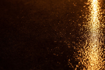 Fototapeta na wymiar Abstract photo reflection of light on a wet surface. yellow neon light on a textured wet surface. Reflection of lights on the pavement.