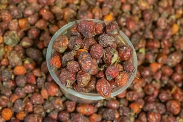 Dried rosehip berries in a box. Large, ripened vegetables. Selling a crop in the market. Natural, healthy, vitamin-rich foods. Food for health.