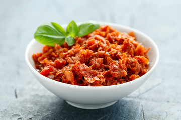 Sun dried tomato pesto in white bowl.
