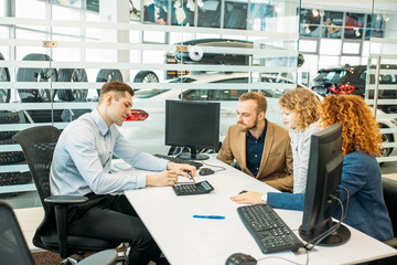 happy caucasian family sign a document before buying new automobile in dealership. people make purchase, buy new perfect car